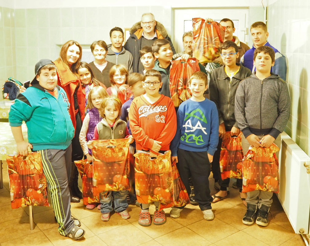 Gruppe von Menschen mit Geschenktüten, symbolisiert Gemeinschaft und Unterstützung.