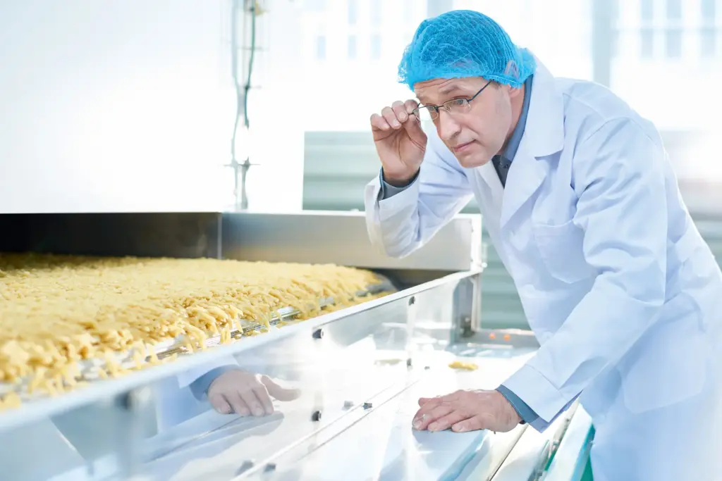 一名身穿防護服的男子正在檢查食品生產過程。