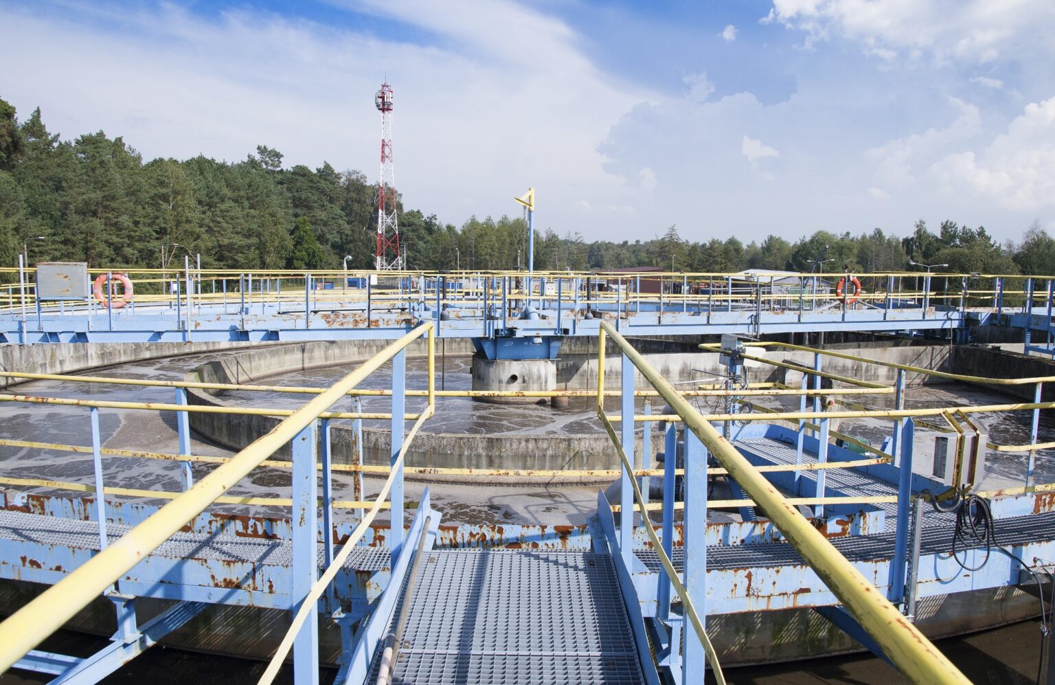 Großes rundes Becken zur aeroben Wasseraufbereitung im industriellen Umfeld.