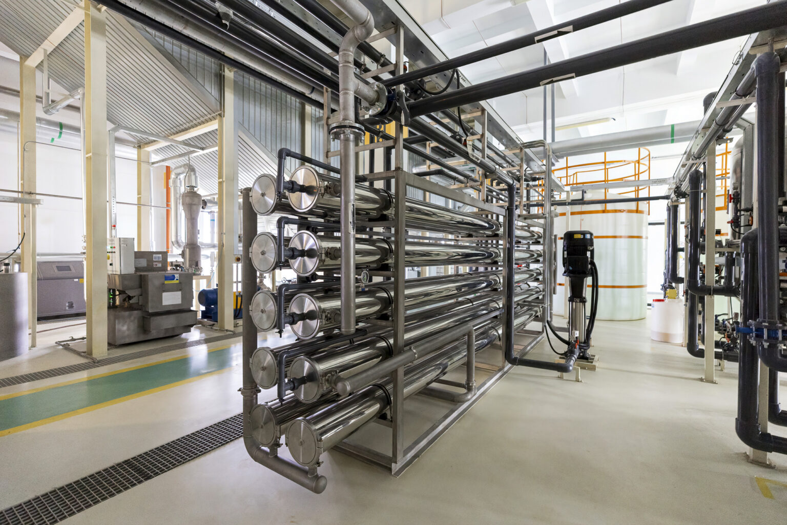 Glänzende Metallrohre zur Wasseraufbereitung durch Enthärtung und Entsalzung in sauberer industrieller Umgebung